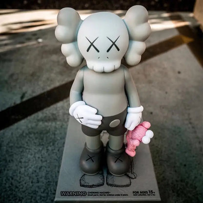 KAWS Figura Coleccionable sosteniendo un muñeco