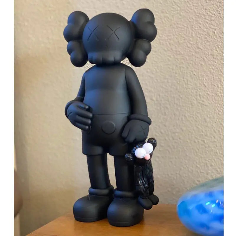 KAWS Figura Coleccionable sosteniendo un muñeco